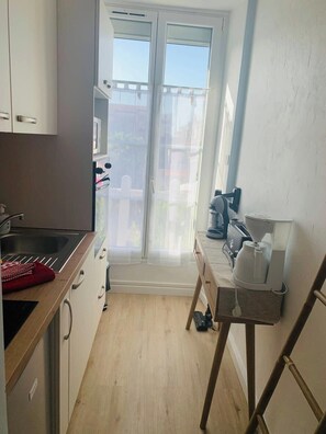 A small kitchen with a sink, cabinets, and a coffee maker on a table. - The Thalassa Centre Rochefort, Ideal for spa visitors, 2* (Rochefort)