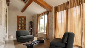 A living room with a sofa, armchair, and a coffee table. - In the Perrines garden, in the heart of Aunis (Marsais)