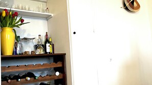 A wine rack with bottles, a yellow vase with red and yellow tulips, and a wall-mounted decorative item.