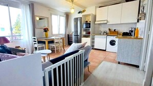 A compact living space with a dining area, kitchen, and a view of the outdoors.