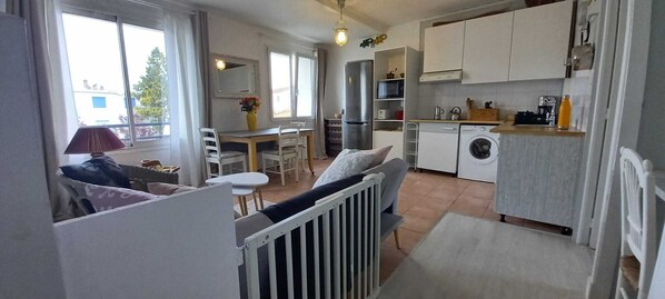 Un appartement compact comprenant une kitchenette, un coin repas et un petit espace de vie.