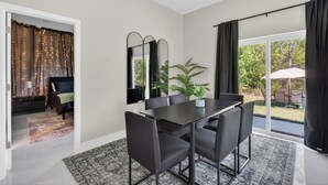 Un comedor con una mesa y sillas, un espejo grande y vistas al exterior.