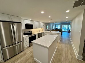 A modern kitchen with stainless steel appliances, white cabinetry, and a central island. - 117 Greens-Updated 2BR w/Golf Views & Steps to Beach (Hilton Head Island)