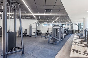 Une salle de sport équipée de divers appareils d’exercice, notamment des tapis de course et des appareils de musculation.
