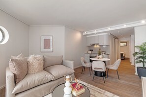 Una sala de estar moderna con un sofá, una mesa de centro y una zona de comedor con sillas y una mesa.