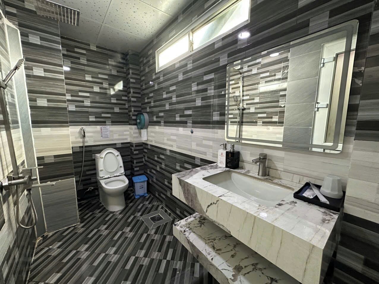 Un baño moderno con inodoro, lavabo y ducha.