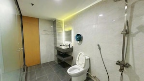 A modern bathroom with a toilet, shower, and vanity. - Kim Linh Hotel  (Ho Chi Minh City)