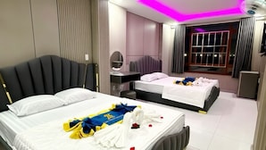 A hotel room with two beds, a desk, a mirror, and a window with curtains. - Kim Linh Hotel  (Ho Chi Minh City)