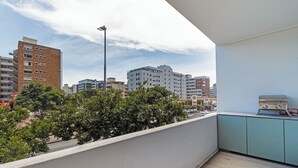 Un balcon offrant une vue sur le paysage urbain, avec des bâtiments et des arbres.