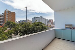 Ein Balkon mit Blick auf eine Stadtansicht, inklusive Gebäude und Bäume.