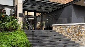 A modern building with a stone facade, a metal staircase, and a glass entrance. - Stylish Stay at The Signature | Central and Modern (Cape Town)