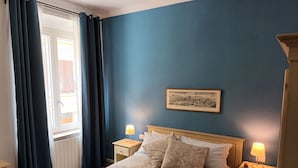 A bedroom with a bed, two bedside tables with lamps, a window with curtains, and a framed picture on the wall. - The Florence Nest B-side (Firenze)