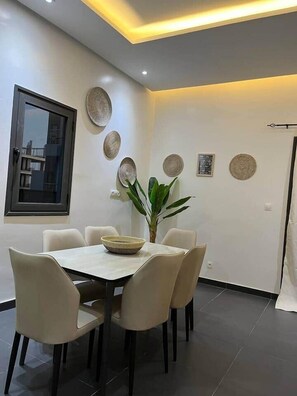 Un coin repas comprenant une table, des chaises et des assiettes décoratives accrochées au mur.