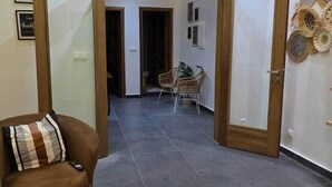 Ein modernes Wohnzimmer mit einem braunen Sessel, einem Teppich und einer Wand mit dekorativen Tellern.