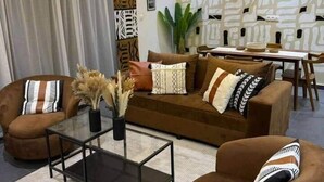 Ein modernes Wohnzimmer mit einer Sofagarnitur, einem Couchtisch und einem Essbereich.