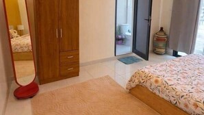 Ein Schlafzimmer mit einem Bett, einem Kleiderschrank, einem Spiegel und einer Klimaanlage.