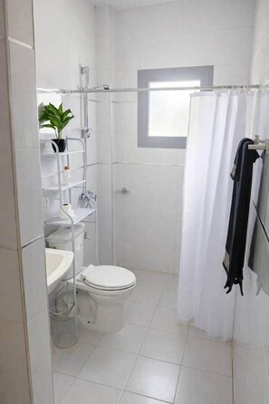 Un baño moderno con inodoro, ducha y lavabo.