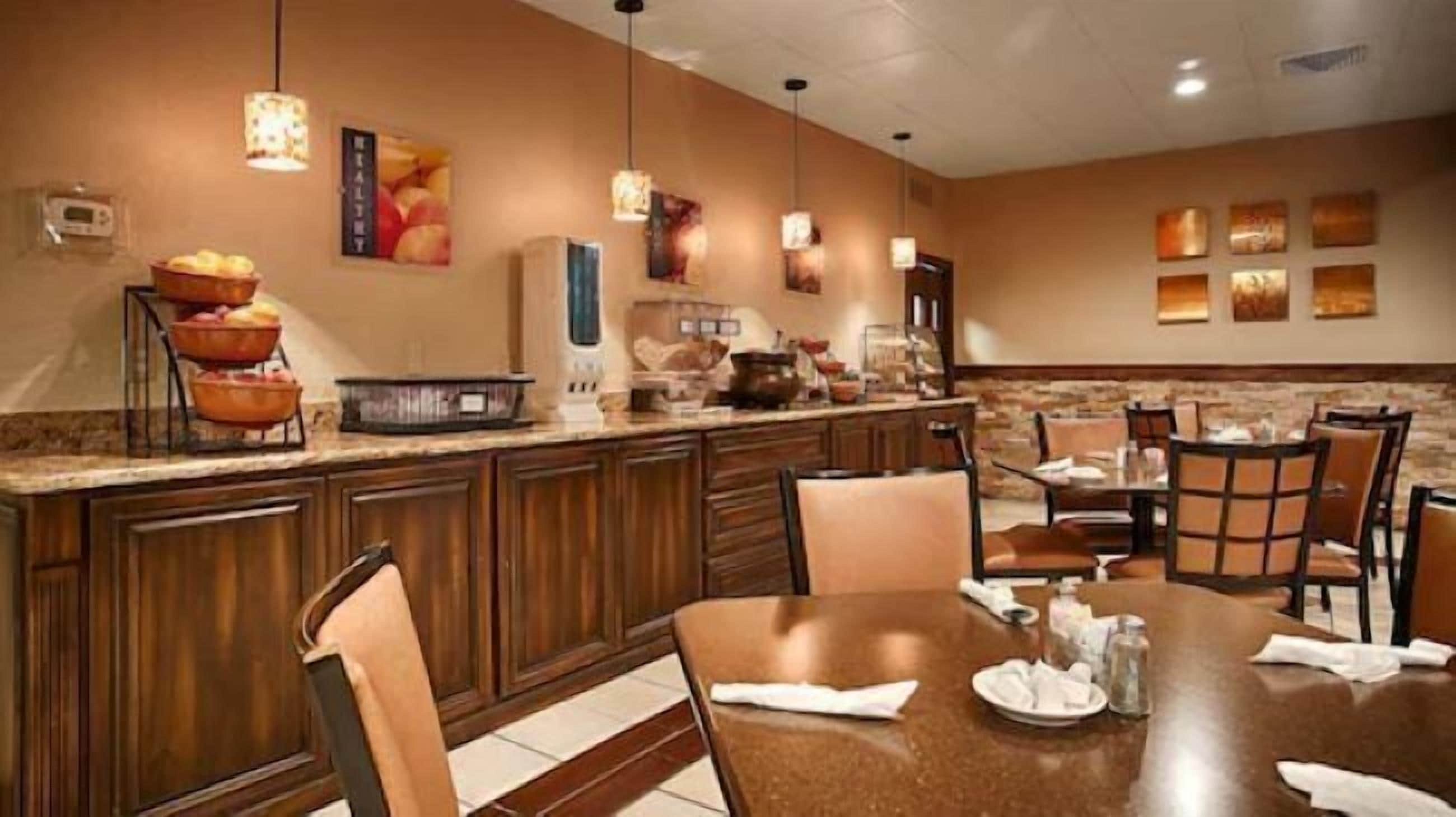 A hotel dining area with a central island, chairs, and tables.