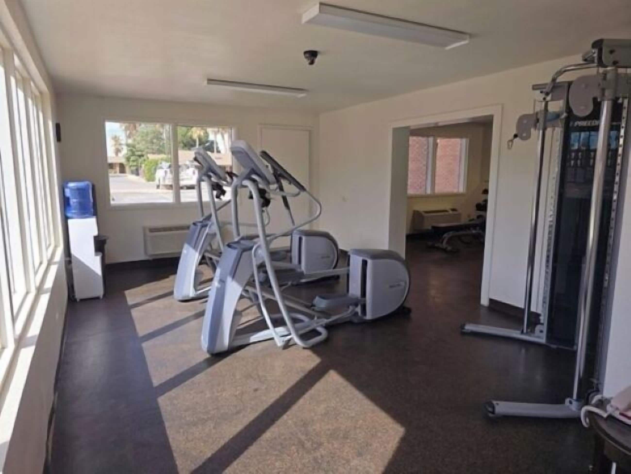 A gym with treadmills, elliptical machines, and a weight machine.