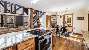 Una cocina amplia con una isla grande, armarios de madera y un comedor con sillas y una mesa.