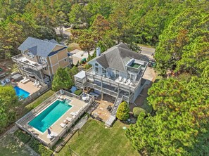Ein mehrstöckiges Haus mit Schwimmbad, Außenbereich und einer großen Terrasse.