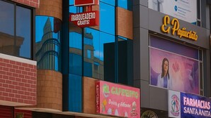A building with a prominent 'HOSTAL' sign, a clock, and various business signs including 'CEMIDO LA CARDA' and 'FARMACIAS SANTA ANITA'. - HOSTAL SABAOTH (Quito)