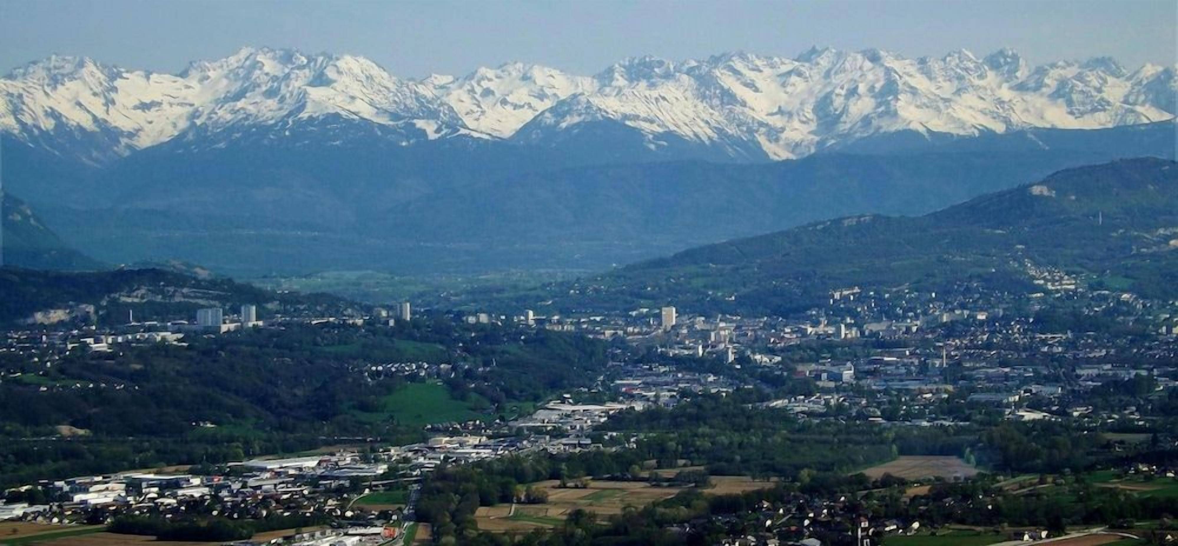 Une ville située au pied de montagnes, où se côtoient des bâtiments résidentiels et commerciaux.