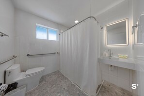Une salle de bain moderne équipée de toilettes, d’une douche et d’un lavabo.