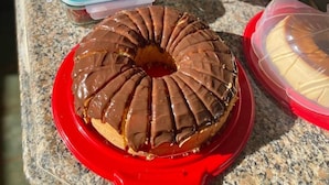 A buffet table with various food items, including a chocolate-covered donut on a red plate. - Novo Hotel Maracaipe (Ipojuca)