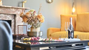 Una mesa de comedor con un centro de mesa floral, una botella de vino y una copa.