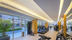 Un gimnasio moderno con cintas de correr, máquinas de pesas y bancos.
