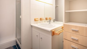 A bathroom with a white sink, wooden towel racks, a mirror, and a wooden cabinet with drawers. - Marvel Morillon - 10 min de la station (Morillon)