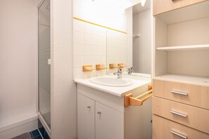 A bathroom with a white sink, wooden towel racks, a mirror, and a wooden cabinet with drawers. - Marvel Morillon - 10 min de la station (Morillon)