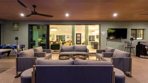 A modern living room with a sofa set, a pool table, and a ceiling fan. - Luxury 5BR Scottsdale Villa: Pool, Spa, Pickleball, Golf Simulator, Gym and More (Scottsdale)