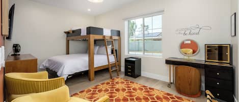 A bedroom with a bunk bed, a desk, a chair, a dresser, a mirror, and a motivational quote on the wall.