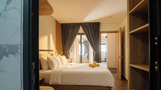 Een hotelkamer met een bed, een bureau, een kledingkast en uitzicht.