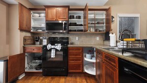 A kitchen with wooden cabinets, a microwave, a stove, and a dishwasher.