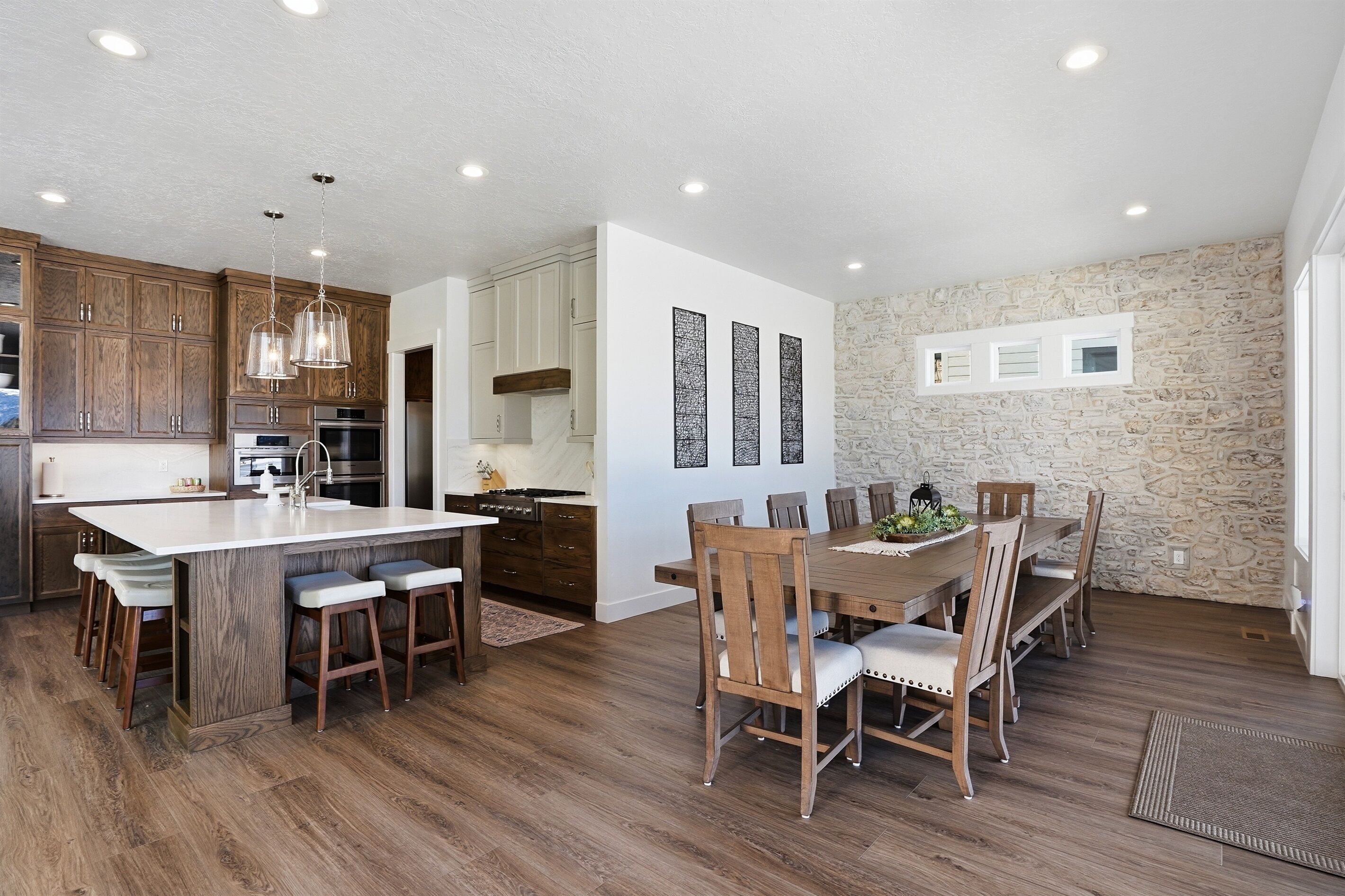 A modern kitchen with wooden cabinets, a large island, and pendant lighting.