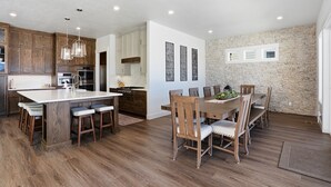 Een moderne keuken met houten kastjes, een groot eiland en hanglampen.