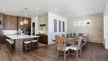 A modern kitchen with wooden cabinets, a large island, and pendant lighting.