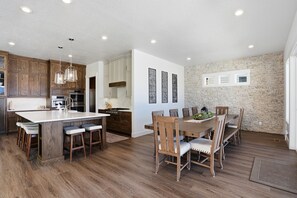 Una cocina moderna con armarios de madera, una isla grande e iluminación colgante.