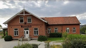 A brick building with a gabled roof, a front entrance, and a sign that reads 'Brückhardt.' - Villa Bäckagård Bed & Breakfast (Åstorp)