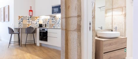 Una cocina moderna con microondas, estufa y taburetes de bar.