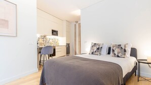 Ein modernes Hotelzimmer mit einem großen Bett, einem Schreibtisch und einem Sessel.