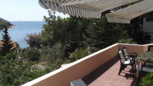 A terrace with a view of the sea, outdoor furniture, and a pergola. - Apartments Zlatko (Vodice)