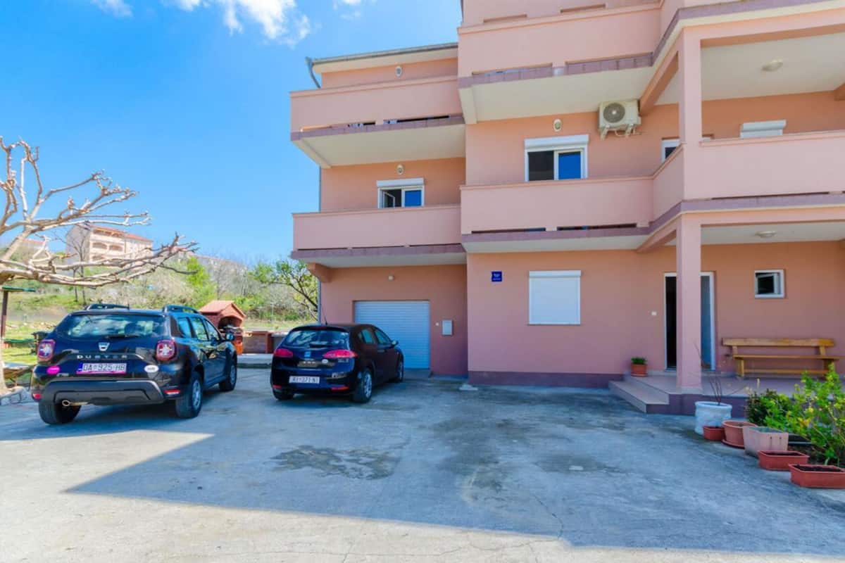Un edificio residencial de varios pisos con un área de estacionamiento.