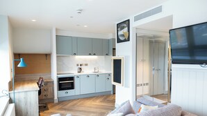 A modern kitchen with light blue cabinets, a marble countertop, and a built-in oven. - Student Only The Parade (Cardiff)