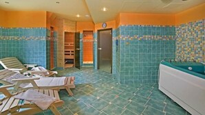 Ein Wellnessraum mit Holzliegen, einer Badewanne und gefliesten Wänden.