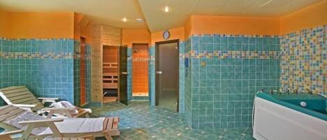 A spa room with wooden loungers, a bathtub, and tiled walls.