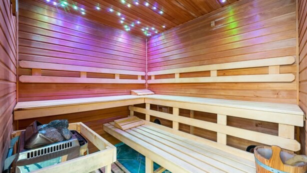 Eine Sauna mit Holzbänken und einem Steinofen.